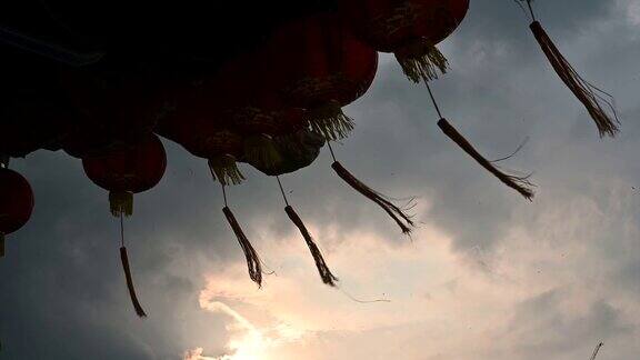 圆圆的红灯笼挂在古老的传统寺庙与美丽的日出