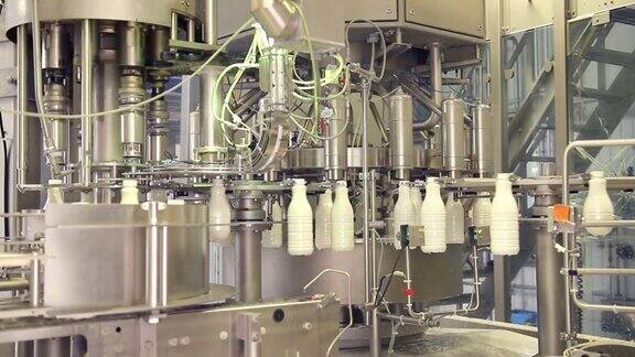 在牛奶公司的生产线上白色塑料奶瓶的镜头瓶子被填充和密封