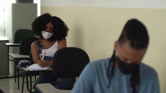 学生们戴着口罩在学校上课