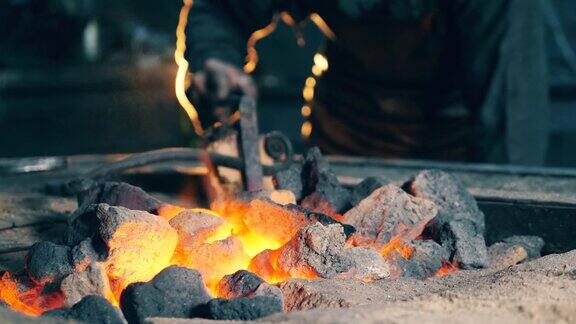 职业铁匠在锻炉工作时检查煤是否着火