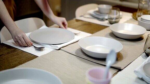 在餐厅里把精致的餐桌上的盘子和刀叉清空