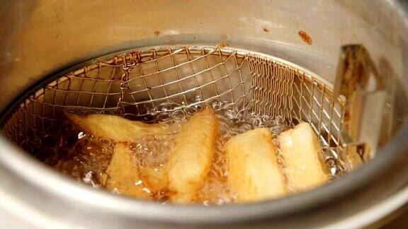 慢速:炸薯条在油锅里炸着