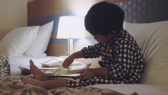 亚洲小男孩晚上在床上看书