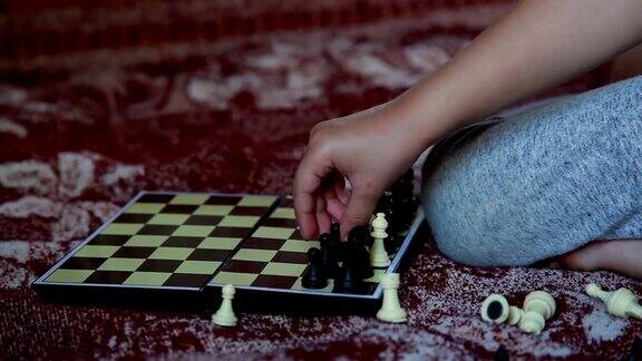 手近距离的一个孩子安排在国际象棋棋盘上的黑色棋子