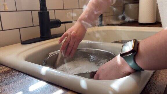 年轻女子用一块抹布在厨房洗碗