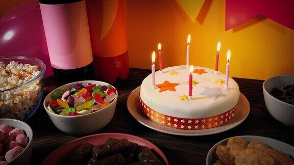 生日蛋糕和点燃的蜡烛放在桌子上
