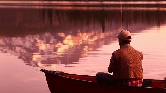 黄昏时分有人在独木舟上钓鱼
