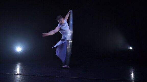 肌肉发达的马戏团艺术家在锡尔轮上慢动作旋转运动、运动和平衡