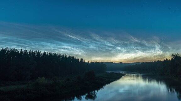森林和河流上空夜光云的时间流逝
