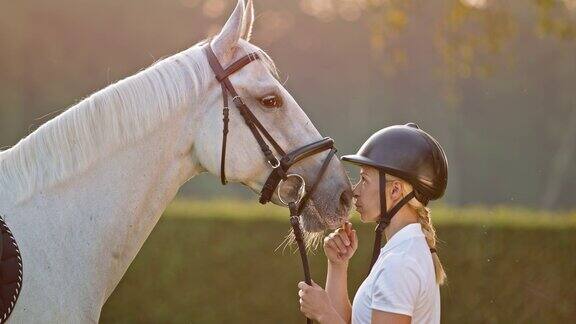 女亲吻她的马的鼻子