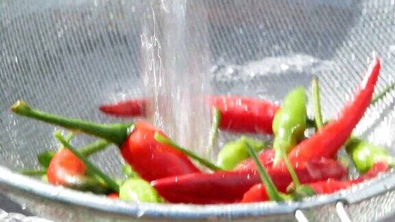 新鲜的红、绿辣椒放入滤锅内用自来水冲洗蔬菜洗净后准备烹调健康饮食