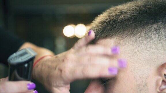 近距离观看男人的头发在理发店用电动剪子剪理发过程的慢动作