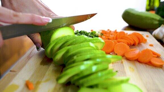 一名妇女切了一根新鲜的黄瓜准备做午餐
