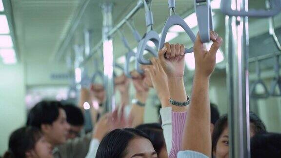 在公共地铁列车上手持把手的通勤者