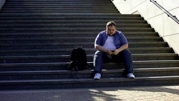 胖子在楼梯上听音乐孤独超重导致不安全感
