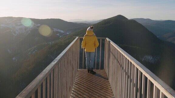 独自旅行者在一个美丽的全景从高山上冬天阳光明媚的户外享受用观光望远镜看全景望远镜