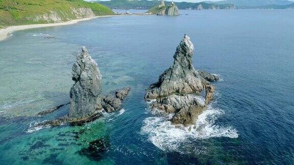 高空倾斜的高海柱高岩石悬崖柱和透明的蓝绿色海水神奇的海景