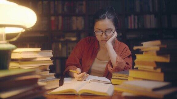 亚洲医科学生深夜在图书馆做研究学业压力大