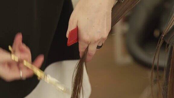 美发师在美容院用剪子为女士理发近距离观看理发师在美发厅用剪刀为女性理发