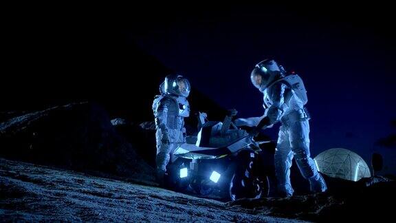 两名宇航员穿着宇航服在外星球上为表面探索任务准备太空车关于太空殖民的未来概念