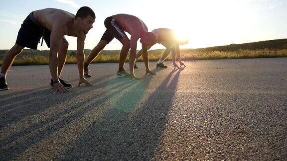 一群运动员在比赛前蹲在起跑线上一起奔跑