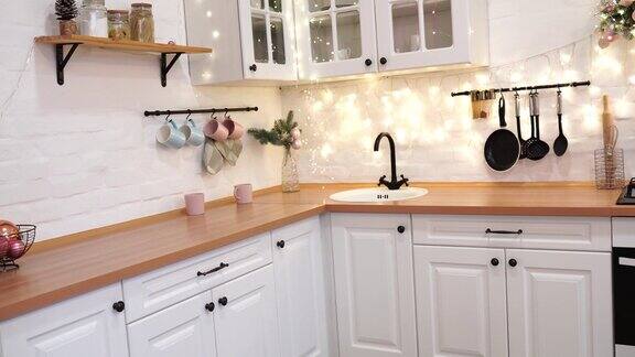 白色厨房内部装饰着圣诞树和花环
