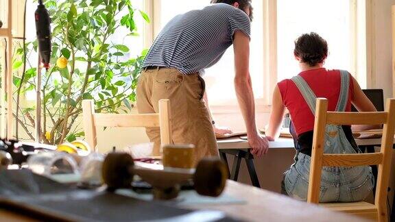 一天在一个创造性的车间一对年轻的夫妇工作和制作一个新的滑板