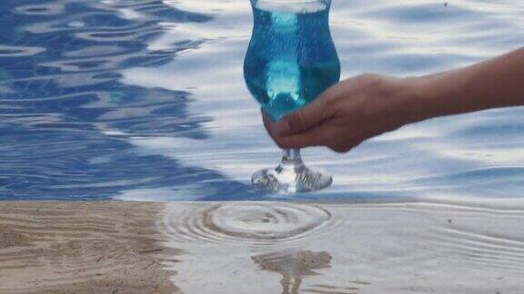 暑假概念父子俩在海边的水里漫步独角兽充气环杯架在泳池边和蓝色泻湖鸡尾酒