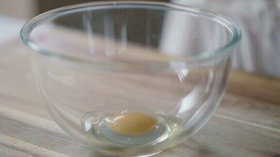用手把鸡蛋打到搅拌碗里