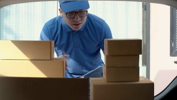 一名亚洲快递员在快递车的后面检查和搬运纸包盒邮政投递服务慢动作4k超高清