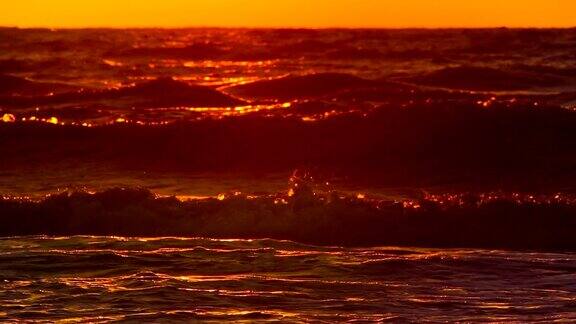 以慢镜头拍过海浪上的日出