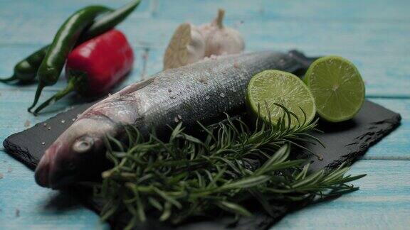 把盐倒在新鲜的鱼上准备烧烤海鲈鱼用香料和盐煮鱼装饰鱼菜