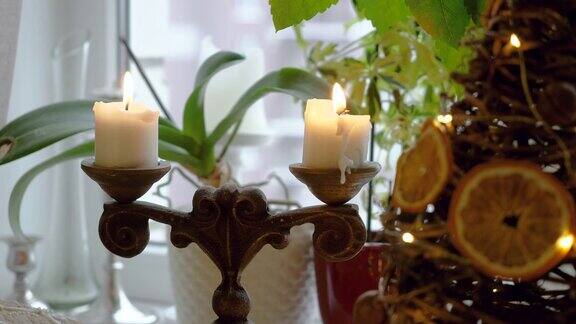 特写两个点燃的白色圣诞蜡烛在一个古董烛台4k