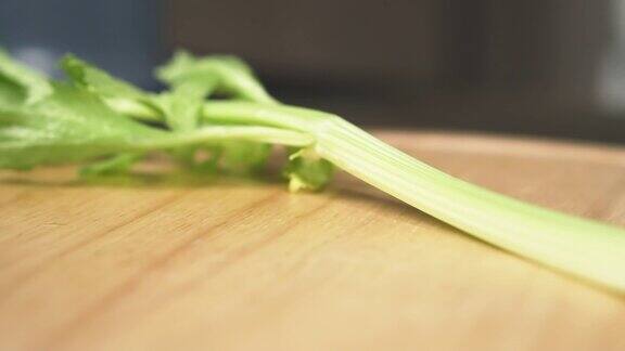 女性用刀切芹菜茎动作缓慢健康食品