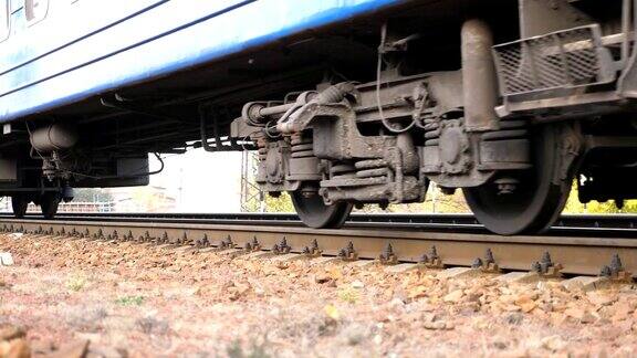 靠近沿着铁轨移动的旋转钢轮的火车旅客铁路运输经过一架照相机交通和旅行低角度视角慢动作