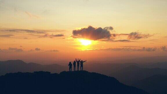 在风景如画的夕阳下四个人在山顶跳舞