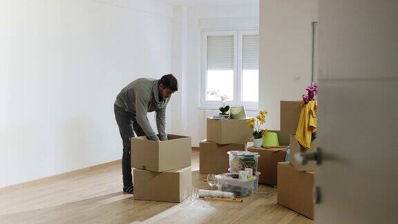 一个男人在他的新公寓里打开纸箱