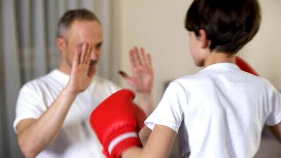 小男孩和他的继父打拳击学习攻击家庭和睦