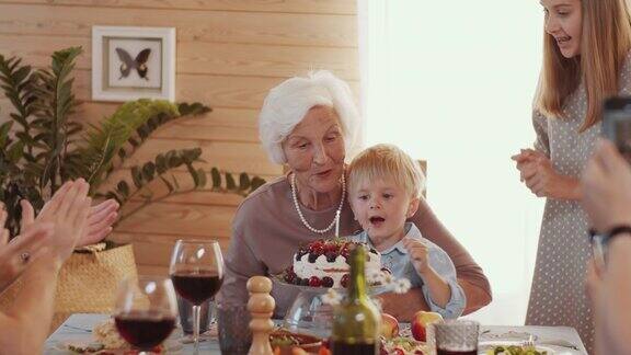 快乐的老女人在家里和家人举行生日聚会