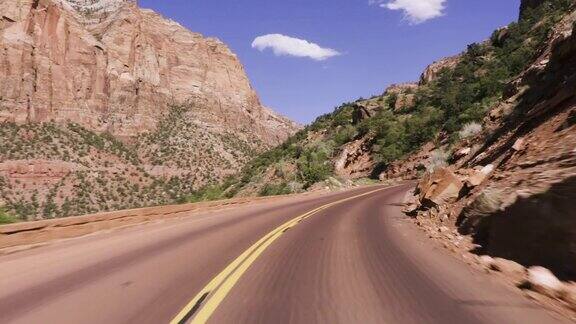 驾驶美国:视角跟踪拍摄沿着山路通过锡安峡谷朝向大拱门锡安国家公园犹他州