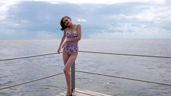 身材柔美的女子来到堤岸苗条的女孩穿着游泳衣在海边快乐的女人站在堤岸上
