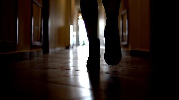 在黑暗的走廊里跟随不认识的穿着靴子的女人的脚步慢镜头