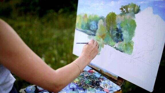 在阳光明媚的夏日里一个迷人的女人坐在公园的格子上用水彩画画出了一幅美丽的风景