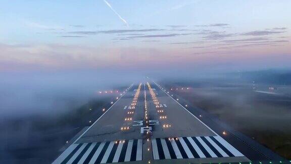 难以置信的驾驶舱视角飞机降落在机场跑道与雾在日落