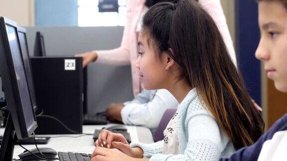 小学女生在计算机实验室集中注意力