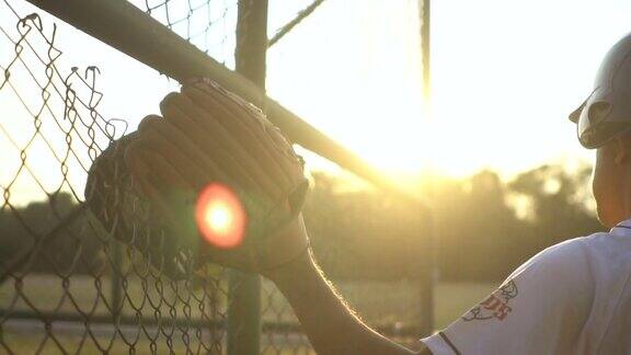 日落时分棒球运动员在空旷的棒球场上练习击球