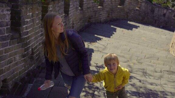 斯坦尼康镜头拍摄了一个年轻的女人和她的小儿子走上中国长城的楼梯