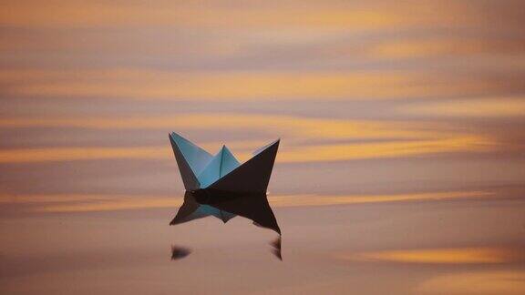 傍晚水面上的折纸船