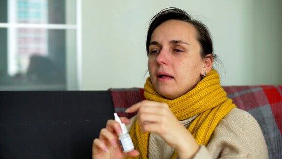 生病的年轻女子使用鼻喷雾剂