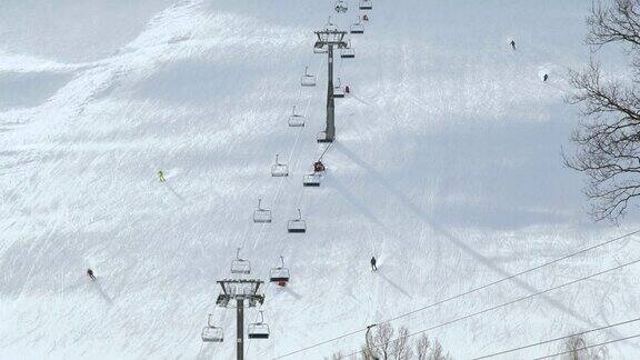 人们在冬季滑雪场的雪坡上滑雪和滑板雪山上的滑雪电梯冬季滑雪胜地的活动